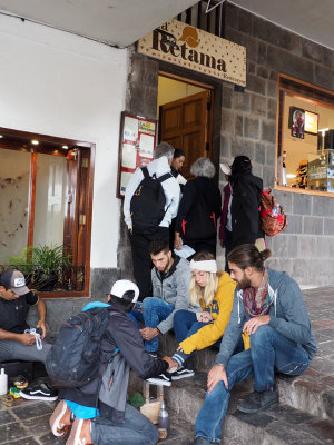 Restaurant entrance and tourist activity in the Plaze de Armas, Cusco