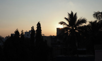 Sun sets behind rooftops of Madipakkam
