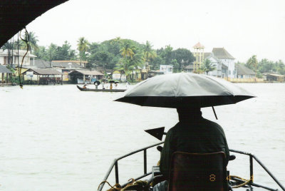 People being ferried across the backwaters in the rain