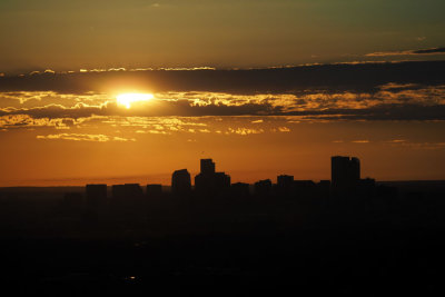 Sun rising into the clouds above Denver