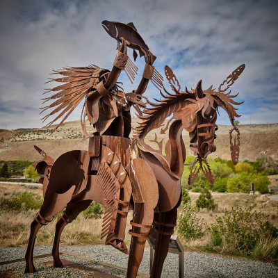 Indian Chief Hoists Fish Over Head