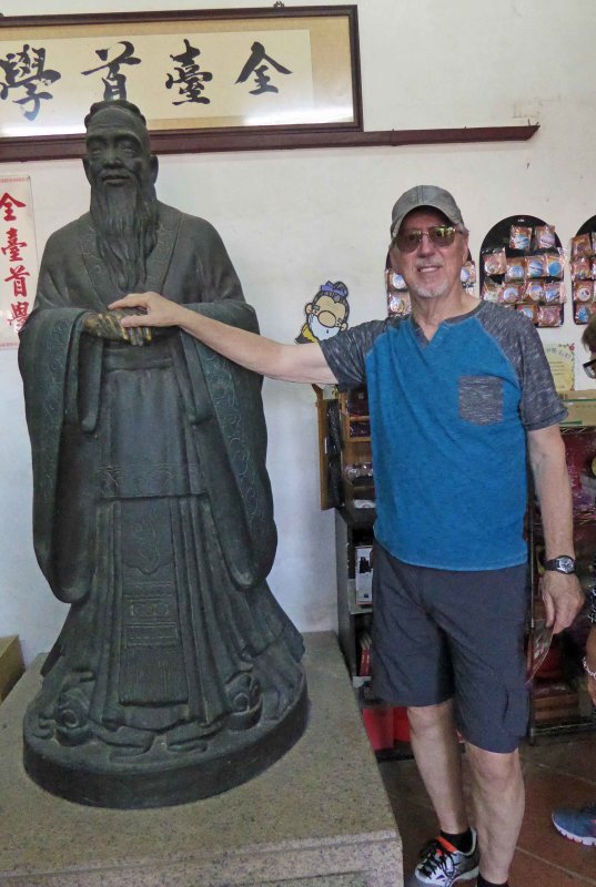 Wishing for good luck by toucing Confucius statues hands
