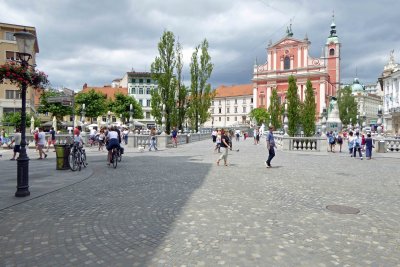Pedestrians crossing the Triple Bridge in Ljubljana