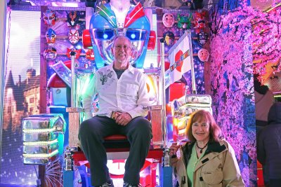 Sitting on giant robot at entry to Robot Restaurant in Tokyo