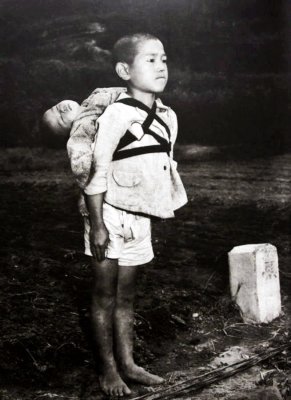 Famous photograph by American Joe O'Donnell of Japanese boy waiting at a crematory to hand over his dead baby brother
