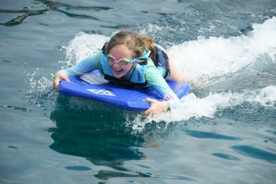 Dolphin pushing Maddie on boogie board