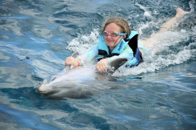 Maddie riding on a dolphin