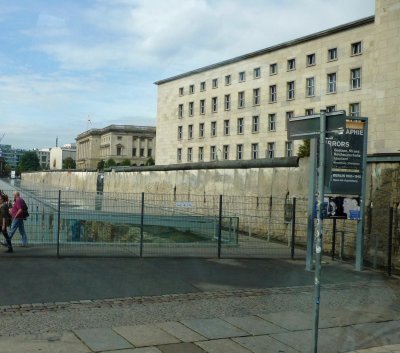 Preserved section of the Berlin Wall with drab East German buildings in the background