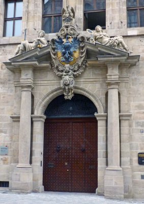 Historic German coat of arms and sculpture over one entrance to Nuremberg City Hall
