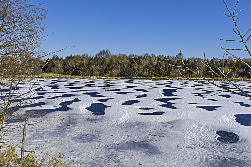 Winter in Nebraska and after a few days of cold and snow, the lake covered in a blue and white design made of nothing but snow and ice.

An image may be purchased at http://fineartamerica.com/featured/snow-and-ice-edward-peterson.html?newartwork=true