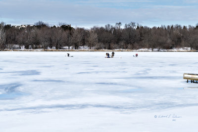 A hardy winter sport is usually hockey, skating or skiing but just standing on the ice waiting for a fish to take the bait seems seems pretty severe. A close look and they all seem to be enjoying the afternoon immensely! I can guess as to what is in those thermoses.

An image may be purchased at fineartamerica.com/featured/hardy-winter-sport-ed-peterso...