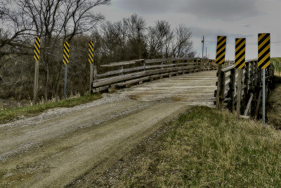 I am guessing more than a few horse teams pulling wagons have gone over this bridge. It has definitely has been there for sometime as some of the beams have been split, there are some boards missing and time has worn some grooves in the bridge bed. It might have even been put up when the railroad was built that runs under the bridge.

An image may be purchased at edward-peterson.pixels.com/featured/old-horse-team-wagon-...