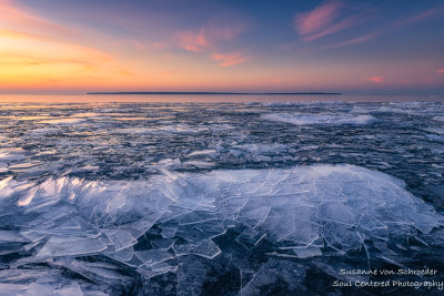 Ice shards at sunset, Sand Island at horizon