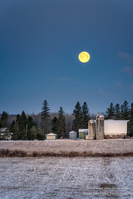 Full moon setting behind a farmstead 1