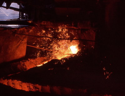 The blast furnace tap hole is open - hot metal flows out