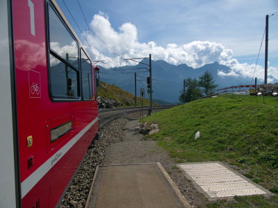 Bernina Express in Alp Grm with view onto the Poschiavo Mountains