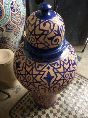 A glazed pot with glaze removed by hand to reveal design