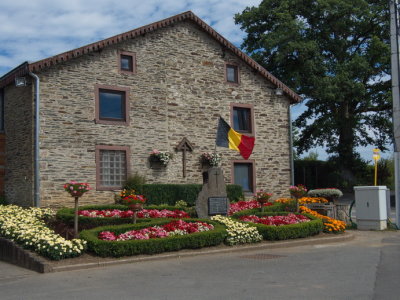 House in Nadrin with monument to the victims of the two World Wars