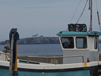 Inner Farne lighthouse framed by a fishing boat