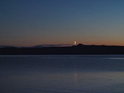 The waxing crescent of the Moon setting behind the Isle of Skye