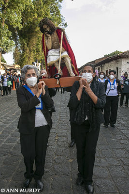 Women carrying seated Cristo