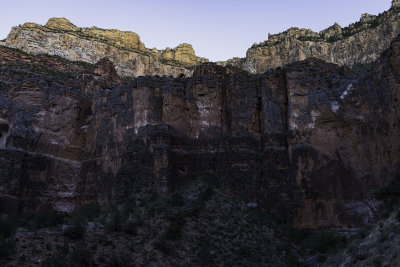 Below the Redwall limestone layer, looking back up trail, the sun has set and alpenglow illuminates the highest cliffs