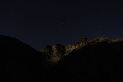 The highest layers of the Tapeats sandstone catch the first rays of moonrise.  The constellation Leo is prominent above.