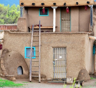 Adobe building with ladders (Hlaukkwima-South House)  and Horno, Taos Pueblo,  New Mexico 140 