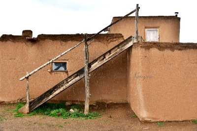 Adobe building with ladders at Taos Pueblo, New Mexico 071 