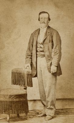 Gentleman Standing by a Fringed Chair