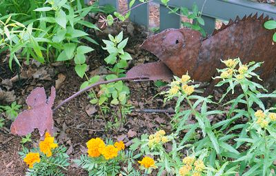 Frog capturing butterfly sculpture.