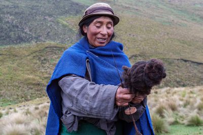 Quechua Shepherdess Spinning Llama Wool into Thread