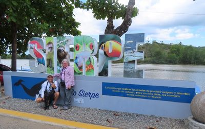 Our guide, Erick, with Mary, in front of the Sierpe sign along the river. Erick pointed out that the sign painter did not know his/her birds, because the toucan on the sign is not seen in this part of the country.