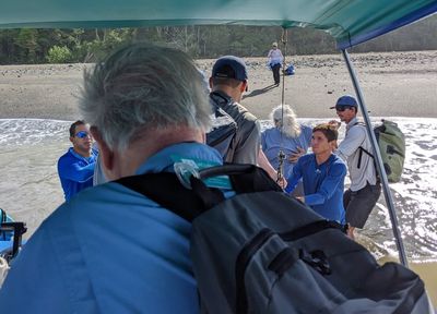 Our driver backed the boat as close to shore as he could, then the crew helped us off the back end of the boat into the water.
One of our boat drivers (L rear), Jerry (in foreground), Erick, Elia (one of our bird guides for the park, first on shore), Dawn, another boat helper, and Jos, our other park guide