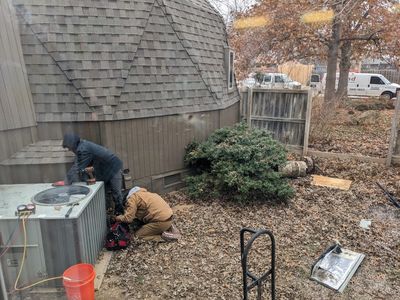 The team of workers took down a section of our wooden fence to take out the old unit and bring in the new one.