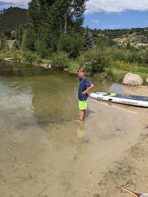 Zane, wading at the water's edge