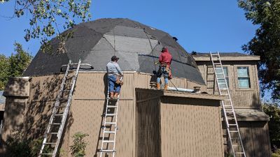 Starting the bottom row of new tar paper on the big dome