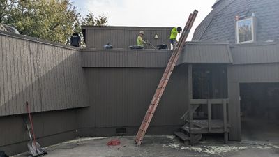 Day 4: The shingles were finished on Friday and the flat roof crew showed up the next Monday. They used a machine similar to a sod cutter, only with scraping (scarping) blades, to remove a layer of the insulation from the flat roof.