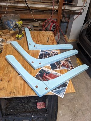 The original seat supports were cut with a curve from a band saw. Not having one, I decided to approximate the slopes (but not the curves) of each part, cutting them by hand on the table saw. I then used the table saw to cut the slot in each new piece to create the lap joint to connect each pair of pieces. Then I painted them and bolted them together.