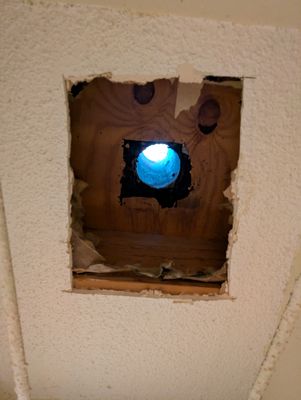 Looking up and out. 
The new vent tubing needs more space around it. They pushed back the insulation in the flat roof space to make room for installing it.