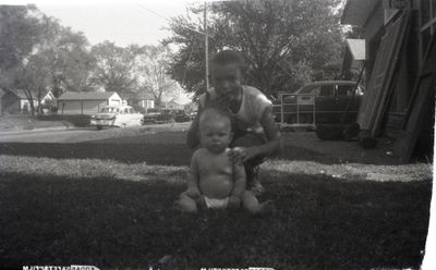Jerry Cordell and unknown girl, in the front yard of the Harris house on S May Ave
196000?  nd  Jerry with unk girl with cars going up and down May