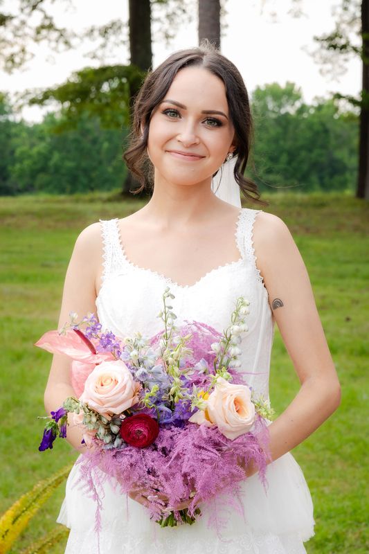 Bride outside with lilac bouquet just before she walks down the aisle.