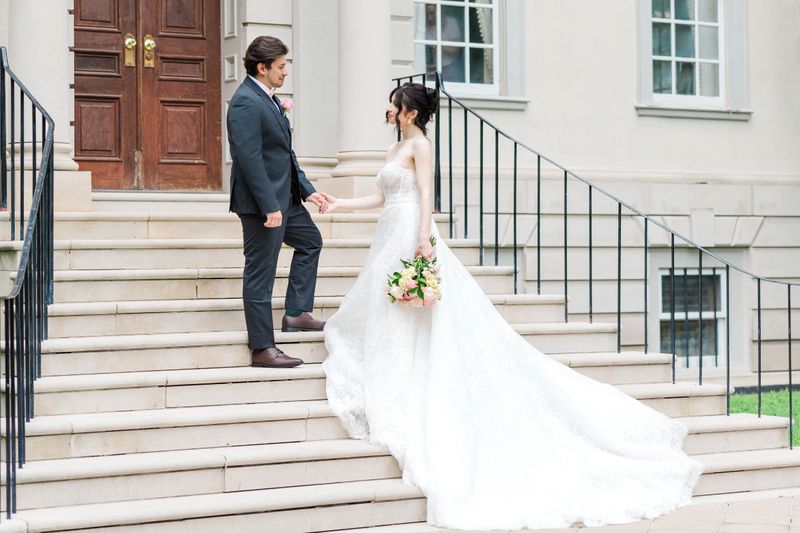 Bride and Groom on grand stairs in front of the Estate where they were married.