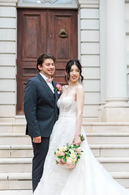 Bride and Groom in front of grand staircase outside of the Estate venue.