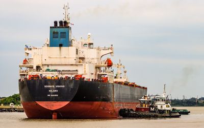 Tug boats push a tanker on the Delaware River