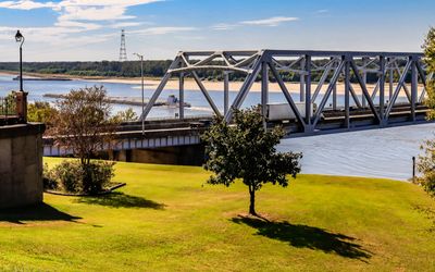 Mississippi River barge passes under the Vicksburg I-20 auto bridge at Vicksburg Mississippi 