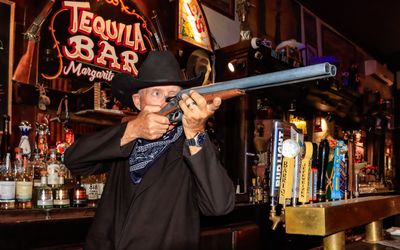 Neer-do-well takes aim from behind the bar at the Crystal Palace Saloon in Tombstone AZ