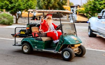 Santa arrives via golf cart for Christmas in July at the KOA RV Park in Tucson