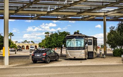 Subaru and RV parked under the solar panel awning at the Tucson KOA RV Park