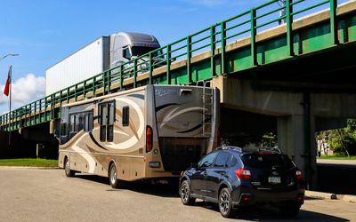 RV and Subaru parked under the I-75 southern entrance to the Mackinac Bridge and the Upper Peninsula of Michigan